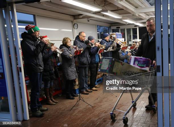 The Soham Comrades brass band get shoppers into the Christmas spirit with Christmas carols played in the entrance lobby at Tescos supermarket on...
