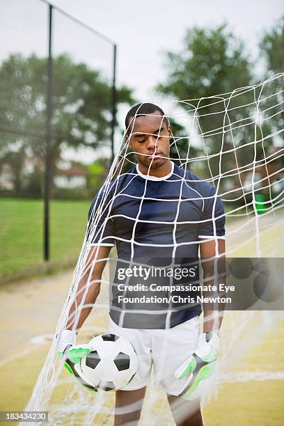 soccer goalie standing with ball in net - bad goalkeeper stock pictures, royalty-free photos & images