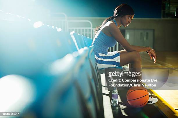 basketball player sitting in gym - female basketball player stockfoto's en -beelden