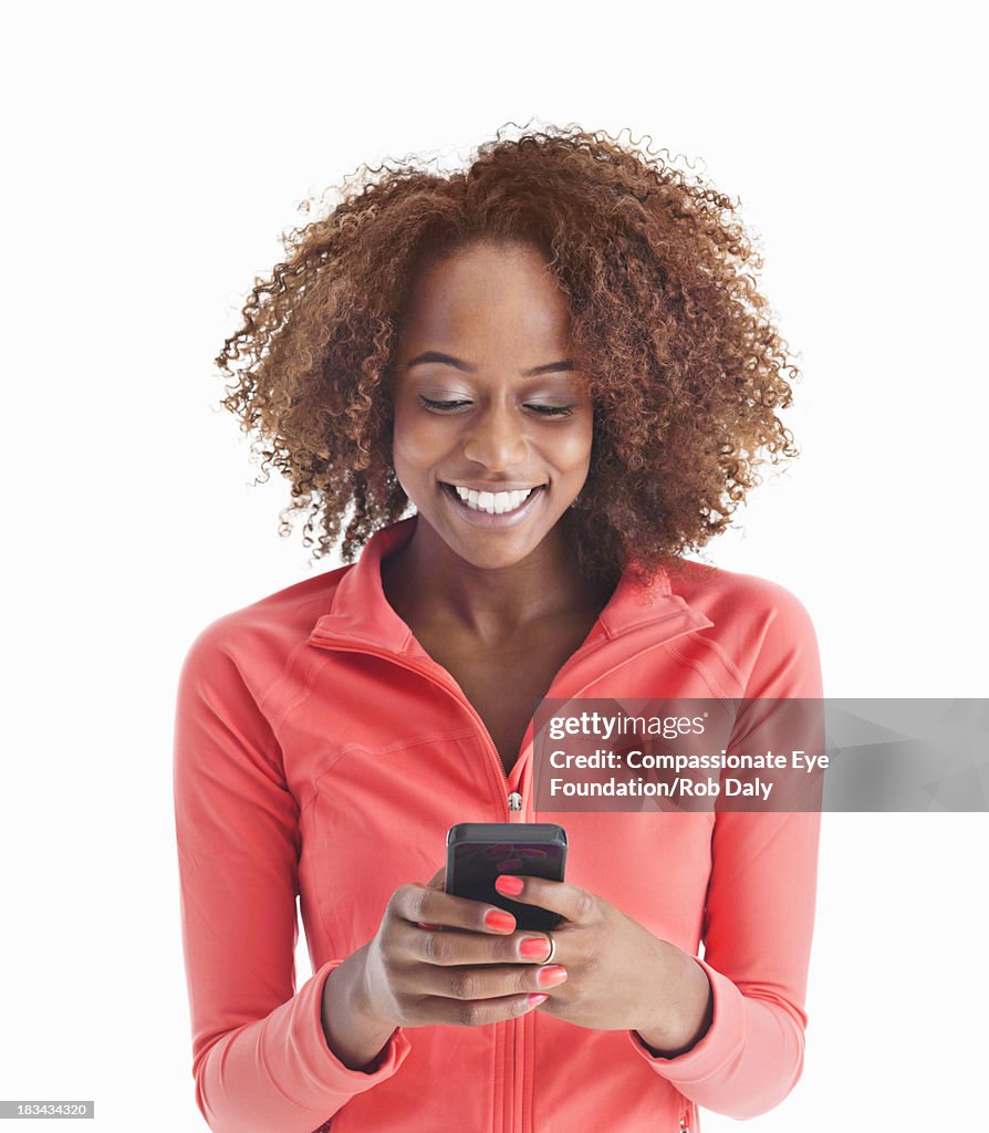 Smiling woman texting on mobile phone