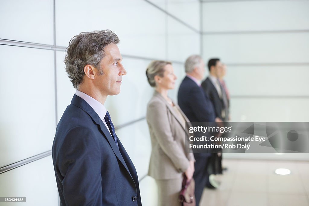 Business people in lobby standing in a line