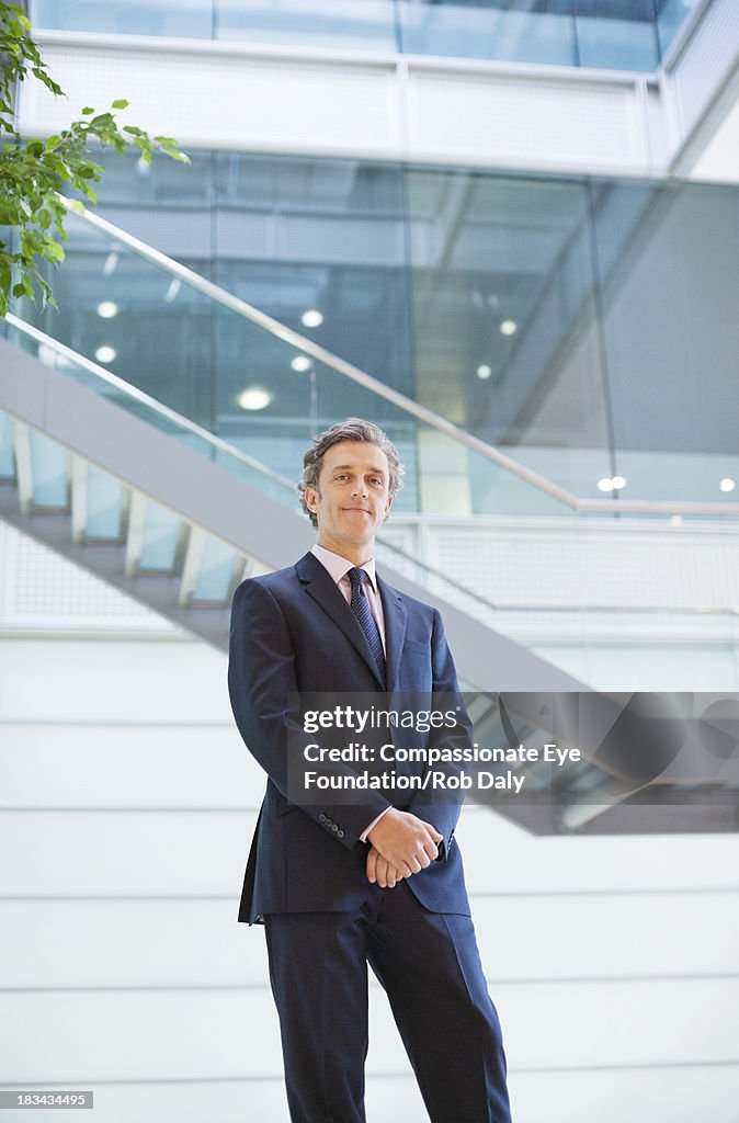 Portrait of smiling businessman in modern lobby