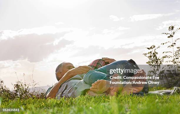 couple laying in grass hugging - aylesbury stock-fotos und bilder