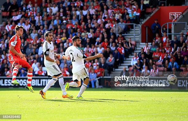 Jay Rodriguez of Southampton shoots past Chico Flores and Jordi Amat of Swansea City to score their second goal during the Barclays Premier League...