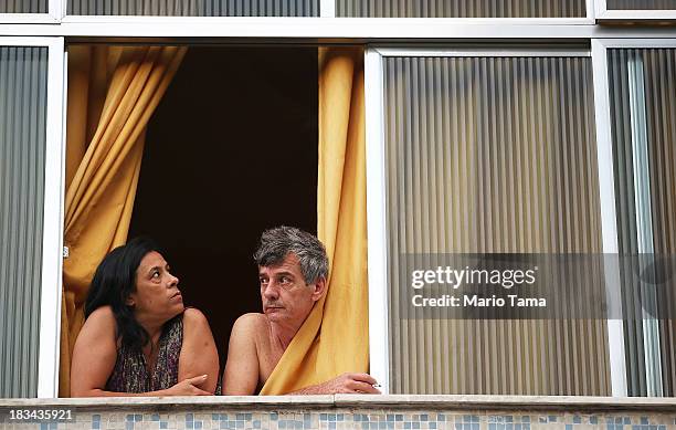 People watch from a window as military forces prepare for a 'pacification' operation in the nearby favela complex of Lins de Vasconcelos, in the...