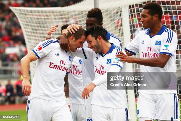 Pierre-Michel Lasogga of Hamburg celebrates his team's fourth goal with team mates Tolgay Arslan and Jonathan Tah during the Bundesliga match between...