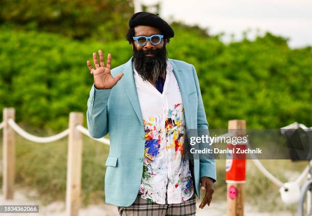 Artist BK Adams is seen wearing a teal blazer, white print shirt, plaid pants with a black beret and light blue glassesoutside the Scope Art Show on...