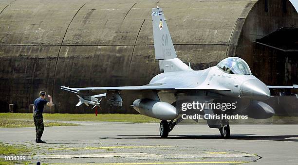 Ground controller salutes a F-16 fighter jet March 7, 2003 at Incirlik Air Force Base in Turkey. Activity at Incirlik, one of the Air Force's main...