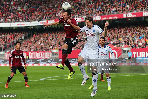 Josip Drmic of Nuernberg jumps for a header with Marcell Jansen of Hamburg during the Bundesliga match between 1. FC Nuernberg and Hamburger SV at...