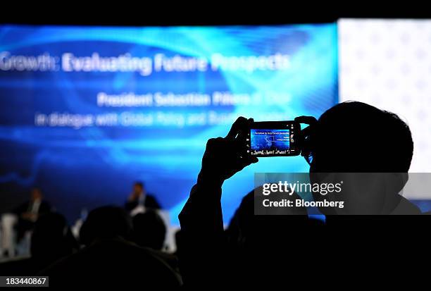 Delegate takes a photograph using his mobile device at the Asia-Pacific Economic Cooperation CEO Summit in Nusa Dua, Bali, Indonesia, on Sunday, Oct....