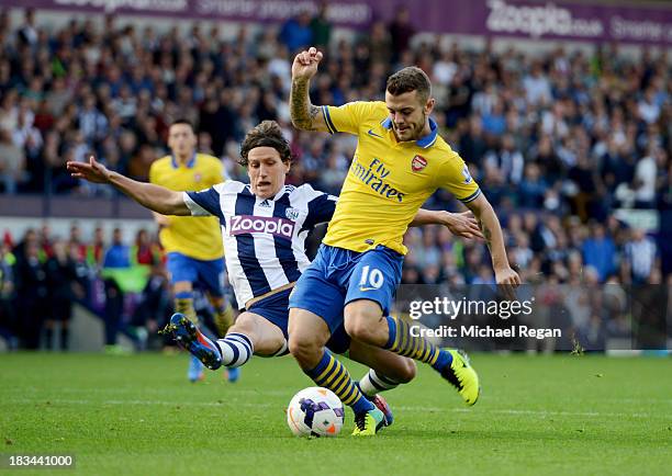 Jack Wilshere of Arsenal is challenged by Billy Jones of West Bromwich Albion during the Barclays Premier League match between West Bromwich Albion...