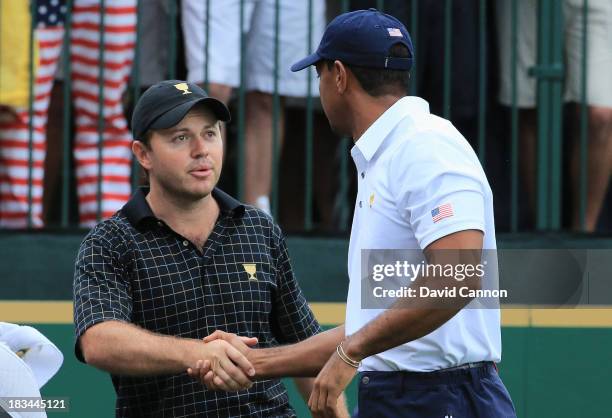 Richard Sterne of South Africa and the International Team shakes hands with Tiger Woods of the U.S. Team on the first tee during the Day Four Singles...