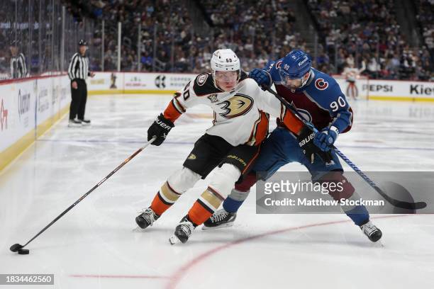 Jackson LaCombe of the Anaheim Ducks advances the puck against Tomas Tatar of Colorado Avalanche in the third period at Ball Arena on December 05,...