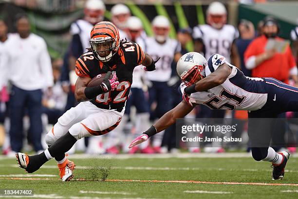 BenJarvus Green-Ellis of the Cincinnati Bengals breaks a tackle attempt from Jerod Mayo of the New England Patriots in the first quarter while...