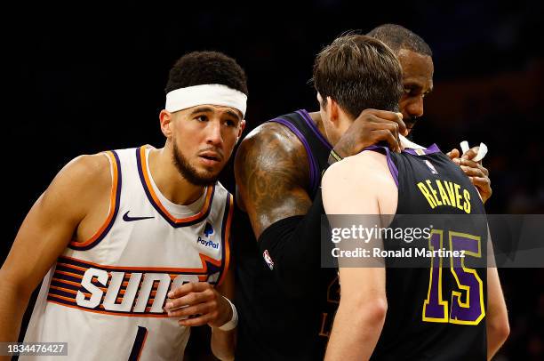 LeBron James talks with Austin Reaves of the Los Angeles Lakers in front of Devin Booker of the Phoenix Suns in the second half during the 2023 NBA...