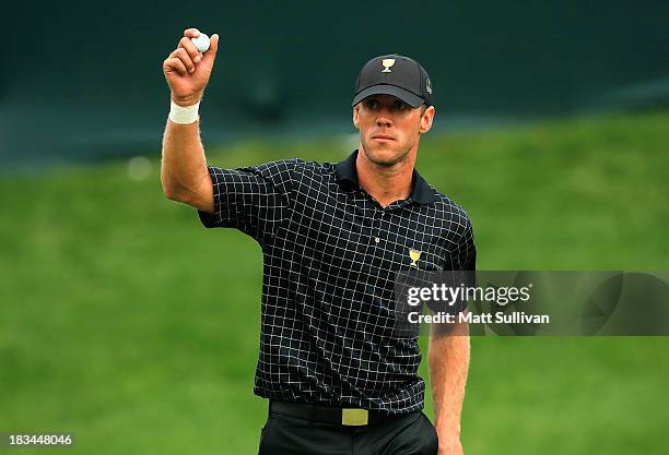 Graham DeLaet of Canada and the International Team waves to the gallery after winning the 16th hole during the Day Four Singles Matches at the...