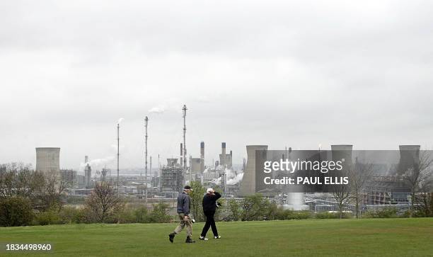 Golfers walk along the fairway in front of the Grangemouth Oil Refinery in Grangemouth, central Scotland on April 25, 2008. Workers at the oil...