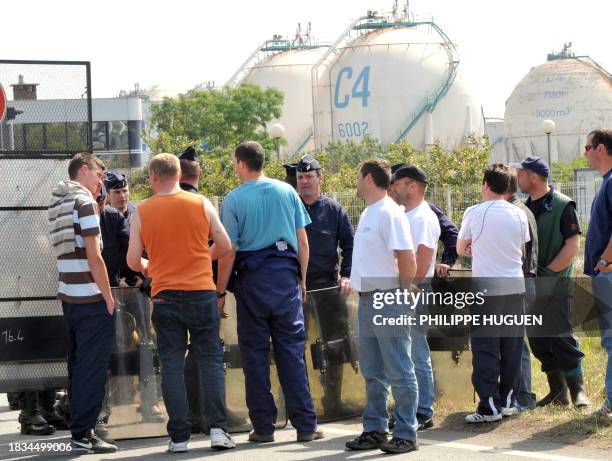 French riot policemen face fishermen protesting high fuel costs as they block access to the Total oil refinery in Dunkirk, northern France, on May...