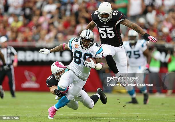 Wide receiver Steve Smith of the Carolina Panthers runs with the football after a reception past defensive end John Abraham of the Arizona Cardinals...