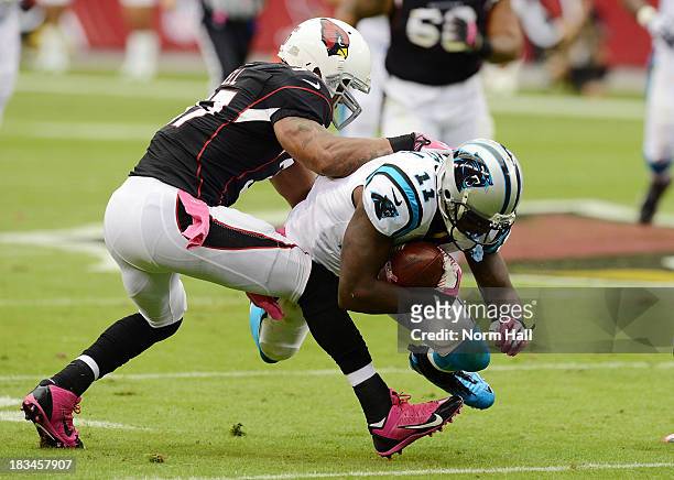 Ted Ginn Jr of the Carolina Panthers dives forward with the ball as Yeremiah Bell of the Arizona Cardinals attempts to make a tackle at University of...