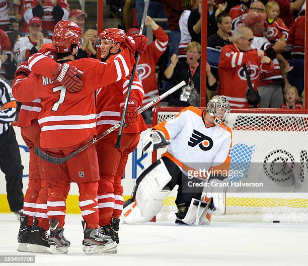 Teammates congratuate Jay Harrison of the Carolina Hurricanes after his goal against Steve Mason of the Philadelphia Flyers during the first period...