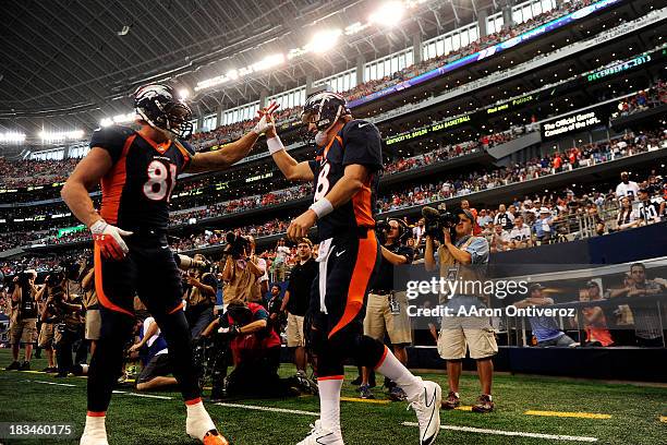 Peyton Manning of the Denver Broncos high fives Joel Dreessen after rushing for a touchdown against the Dallas Cowboys during the first half of...