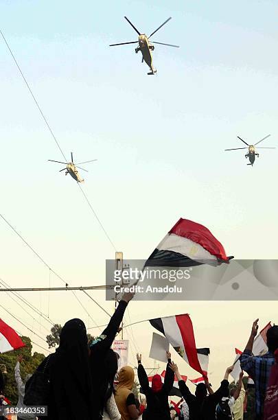 An Egyptian woman waves a national flag as Egyptian military helicopters fly over Tahrir square during the celebration marking the 40th anniversary...