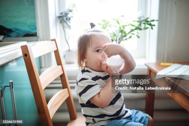 heartwarming morning: toddler enjoying organic milk from mug at home - food allergy stock pictures, royalty-free photos & images