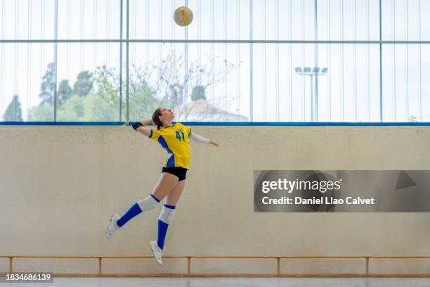 female volleyball player jumping to hit ball - volear fotografías e imágenes de stock