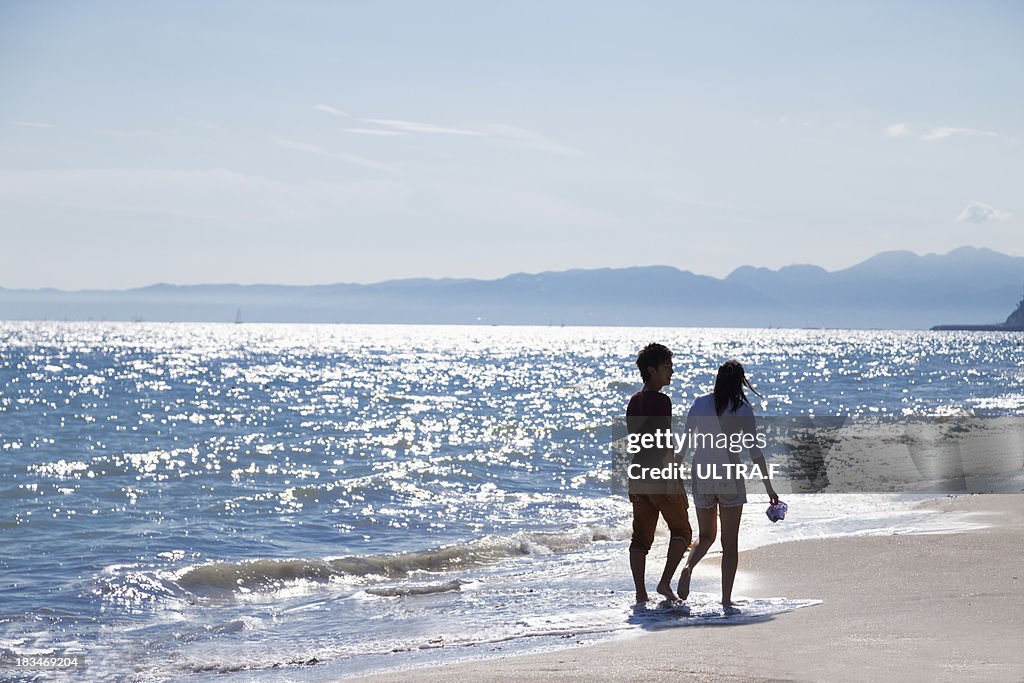 Young couple walking along seashore