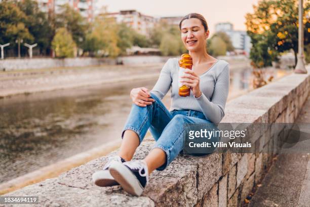 woman eating pastry - breaking croissant stock pictures, royalty-free photos & images