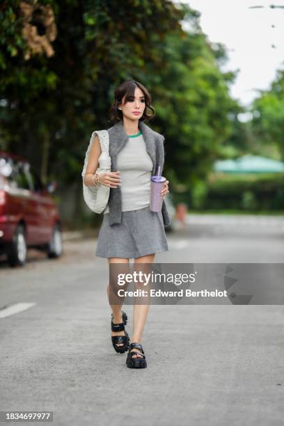 Heart Evangelista wears a gray wool pullover from Cos, a gray t-shirt with green line from Cos, a gray wool mini skirt from Cos, a white woven...