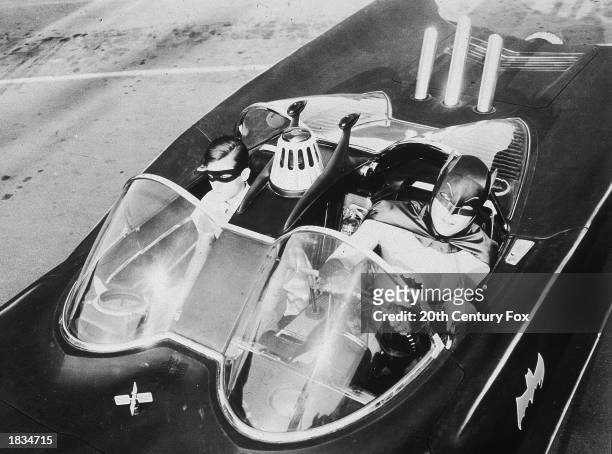 American actors Burt Ward , as Robin, and Adam West, as Batman, ride in the Batmobile in a still from the television series, 'Batman,' c. 1967.