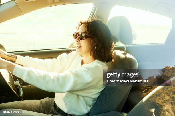 happy young woman in car - vehículo terrestre fotografías e imágenes de stock