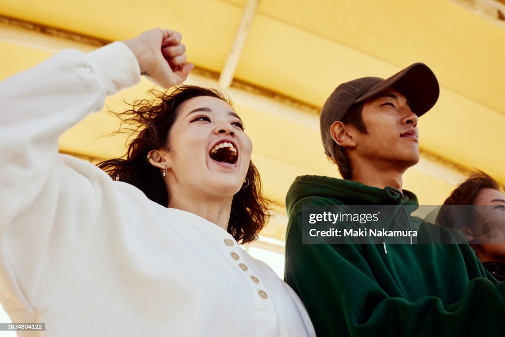 Young people cheering for their friends in the audience.