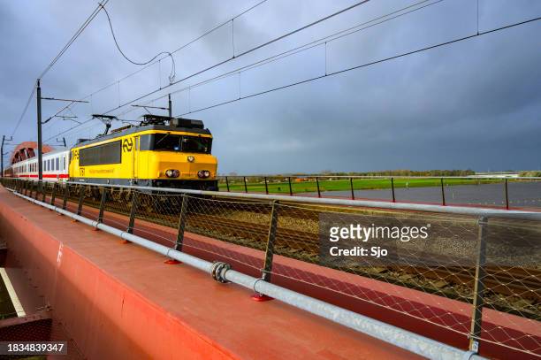 locomotive ns class 1700 of the nederlandse spoorwegen driving over hanzeboog train bridge during its last ride - alstom stock pictures, royalty-free photos & images