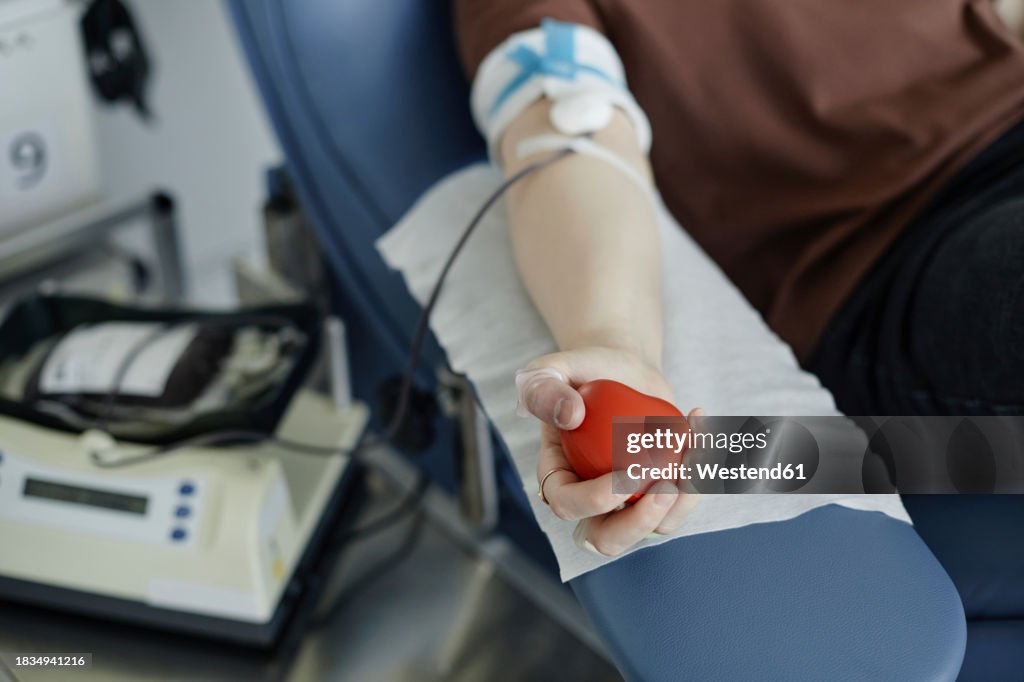 Hand of woman holding soft ball donating blood