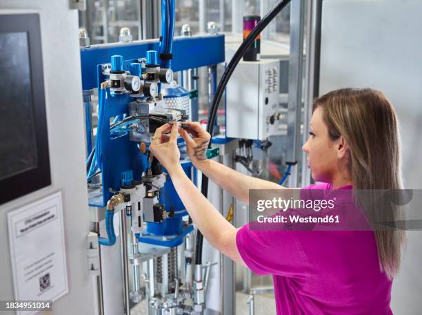 technician adjusting compressed air manifolds on machine - compressed air stock pictures, royalty-free photos & images