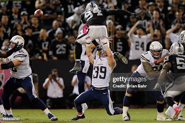 Linebacker Kevin Burnett of the Oakland Raiders hurdles running back Danny Woodhead of the San Diego Chargers to put pressure on quarterback Philip...