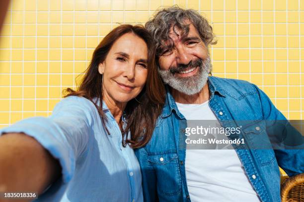 smiling senior couple taking selfie on sunny day - physical position stock pictures, royalty-free photos & images