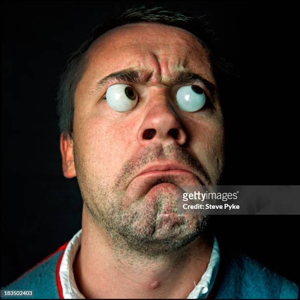 British artist Damien Hirst, poses with two glass eyes on his face, Leyton, east London, 24th August 1999.