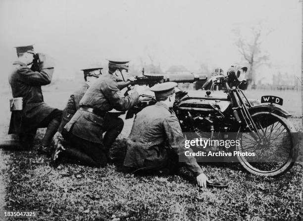 Soldiers from the 1st Motor Machine Gun Service unit of the British Army practice firing a pan magazine fed Lewis automatic light machine gun mounted...