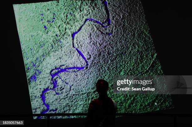 Visitor looks at a rendering from a satellite image of the Yukon River in Alaska in the art installation: "Passage of Water" by Yiyun Kang on day...