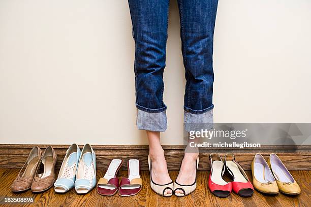 woman stands wearing heels with her collection of shoes - women trying on shoes 個照片及圖片檔