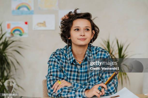 contemplative graphic designer holding colored pencils at office - illustrator stock pictures, royalty-free photos & images