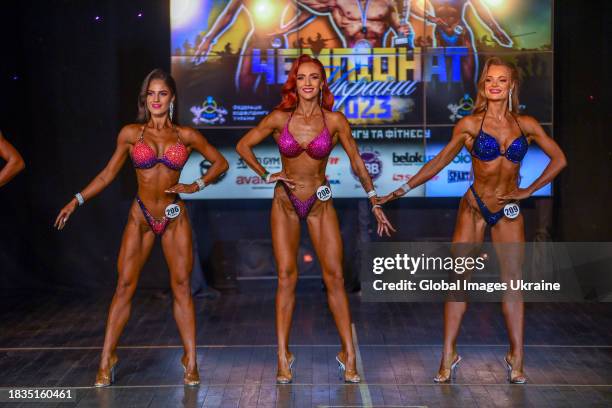 Rymma Tosunova, Viktoriia Kotik, Iryna Miskova compete on stage during the Ukrainian Championship Bodybuilding and Fitness 2023 FBBU IFBB on October...