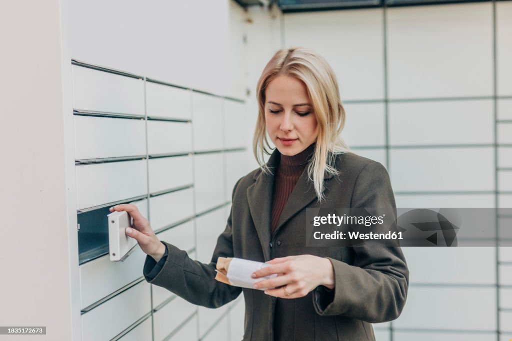 Woman picking up package from parcel locker