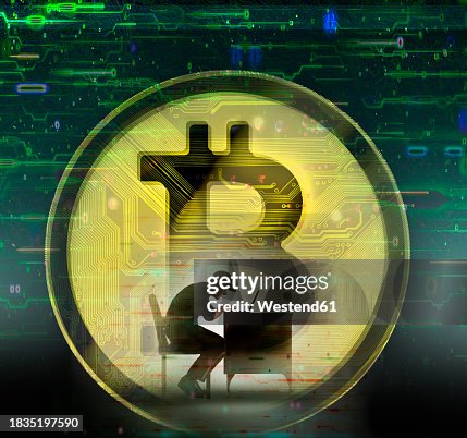 Hacker using laptop against oversized bitcoin Hacker using laptop against oversized bitcoin