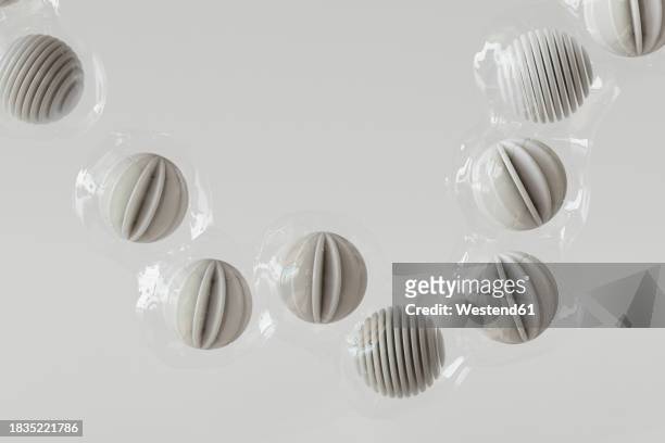 3d render of row of plastic wrapped spheres floating against white background - wrapped stock illustrations