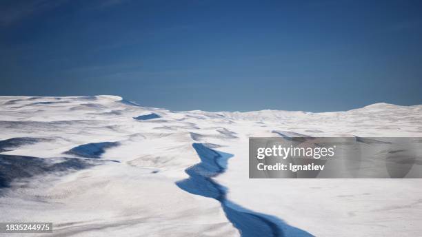 an arctic desert blanketed in frozen, snow-covered landscapes. - deserto ártico - fotografias e filmes do acervo